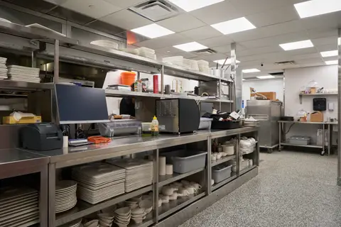plating pass with stacked dishware on stainless shelving