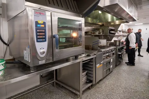 chefs working the cook line beside the combi oven