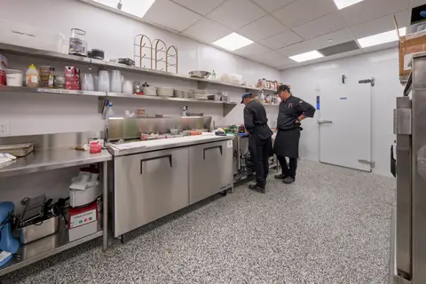 stainless prep counters with refrigerated bases beside the walk-in door
