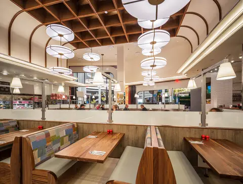 Around the Clock dining room with walnut booths and drum pendants