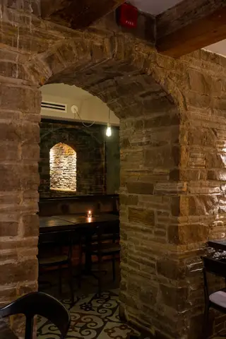 stone archway looking through to a candlelit table