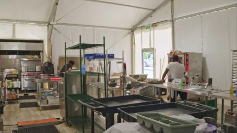 Camp George kitchen with stainless worktables, ovens and cooking equipment