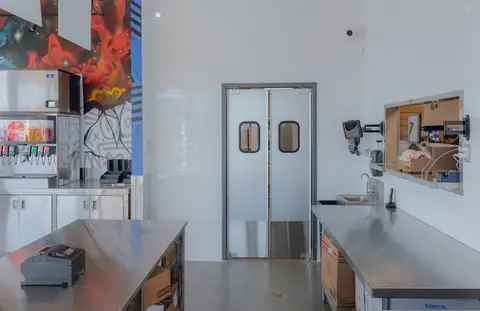 stainless work table and swing doors behind the service line