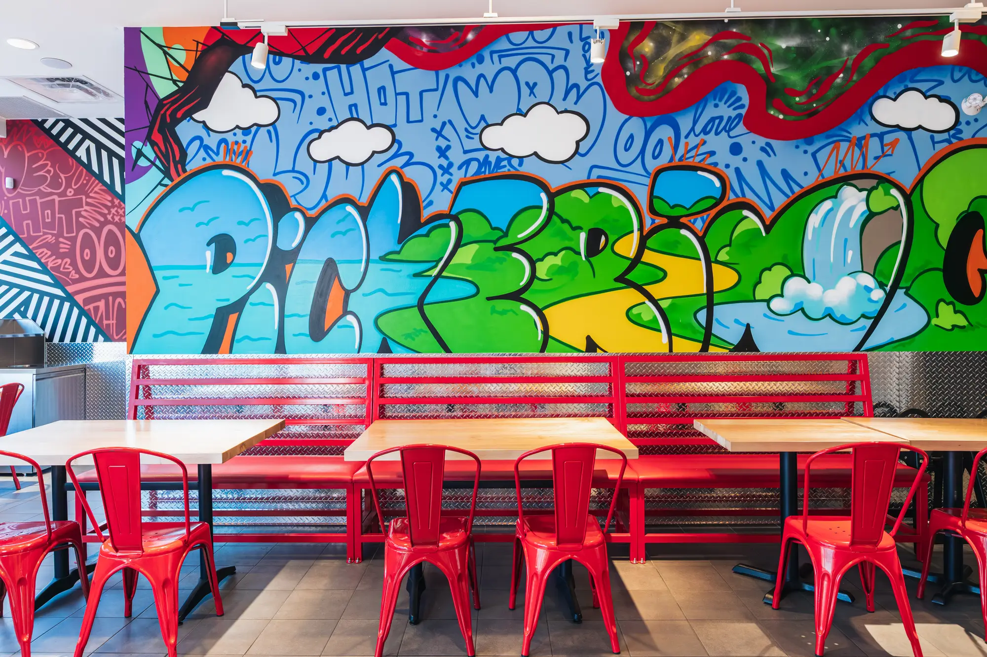 Communal tables and mural wall in the Dave's Hot Chicken Pickering dining room