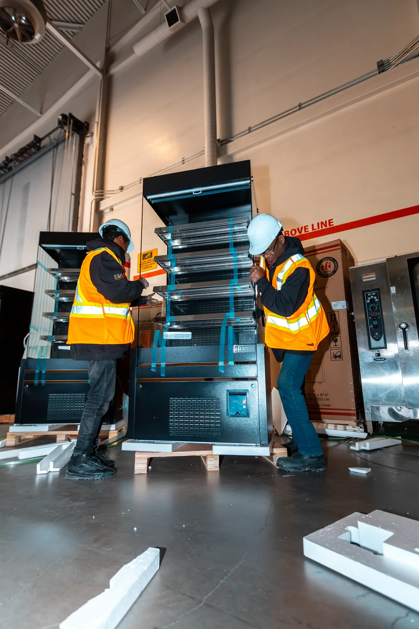 Technicians assembling refrigerated shelving at the Enercare Centre