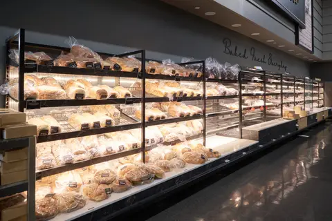 angled bread shelving stocked under a Baked Fresh sign