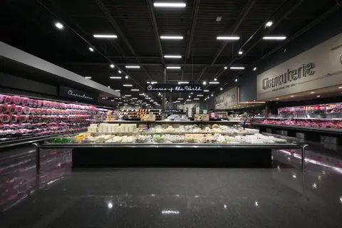 cheese and charcuterie departments seen down the perimeter aisle