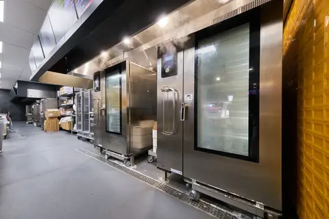 roll-in rack ovens venting steam on a production line with trough drains