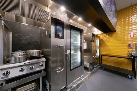 range and oven under an exhaust canopy in the production kitchen