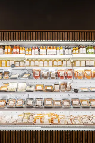 refrigerated grab-and-go wall stocked with bottled juices and prepared food