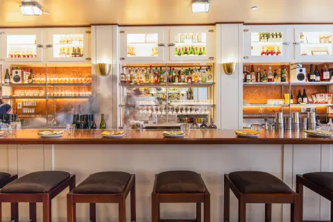 N.L. Ginzburg bar with stools and lit back-bar shelving