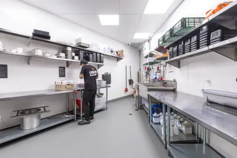 Poulet Rouge prep kitchen with stainless tables and shelving
