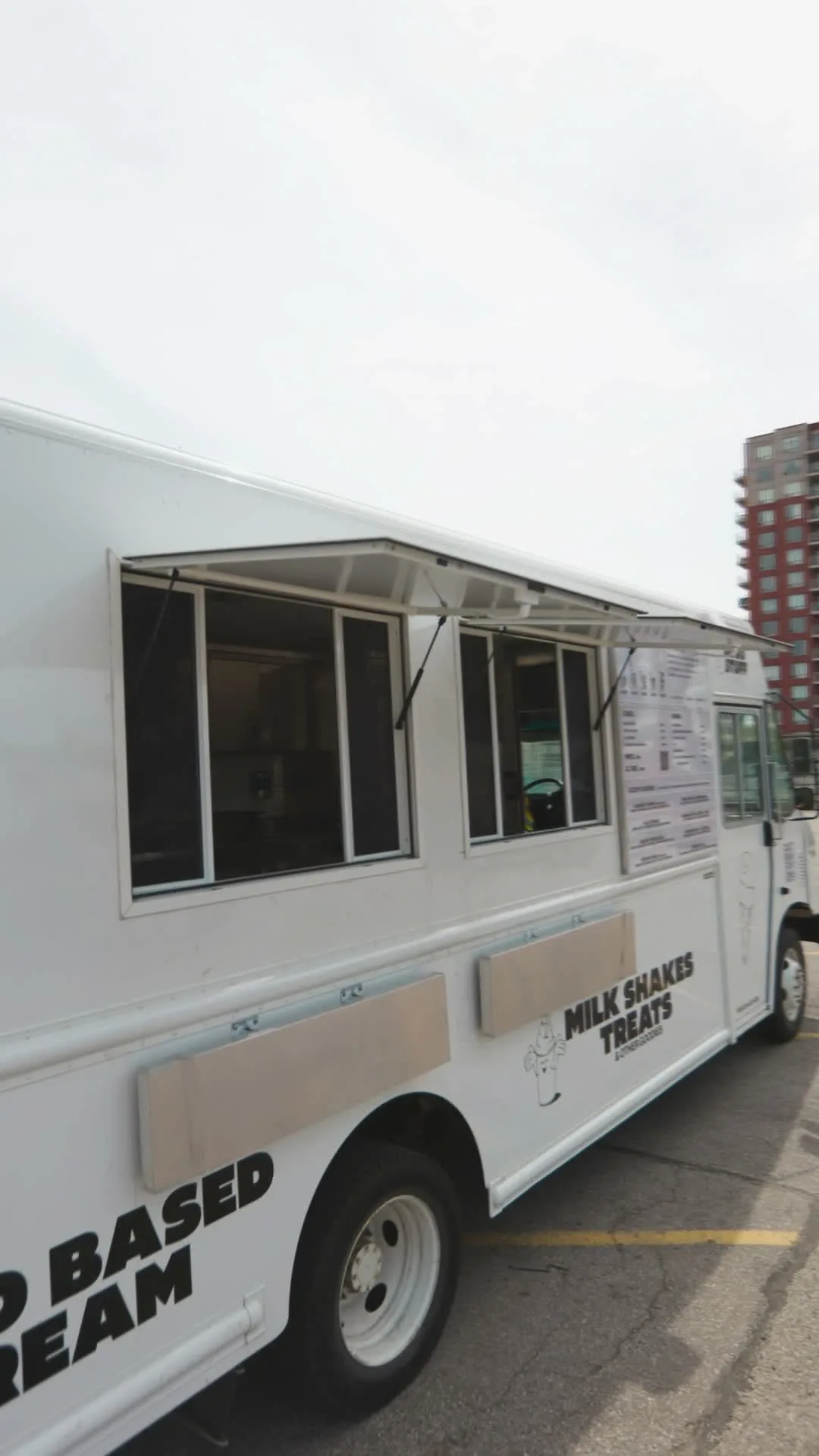 The Ruru Baked food truck built by The Cesario Group, a white step-van outfitted as a mobile commercial kitchen with service windows open