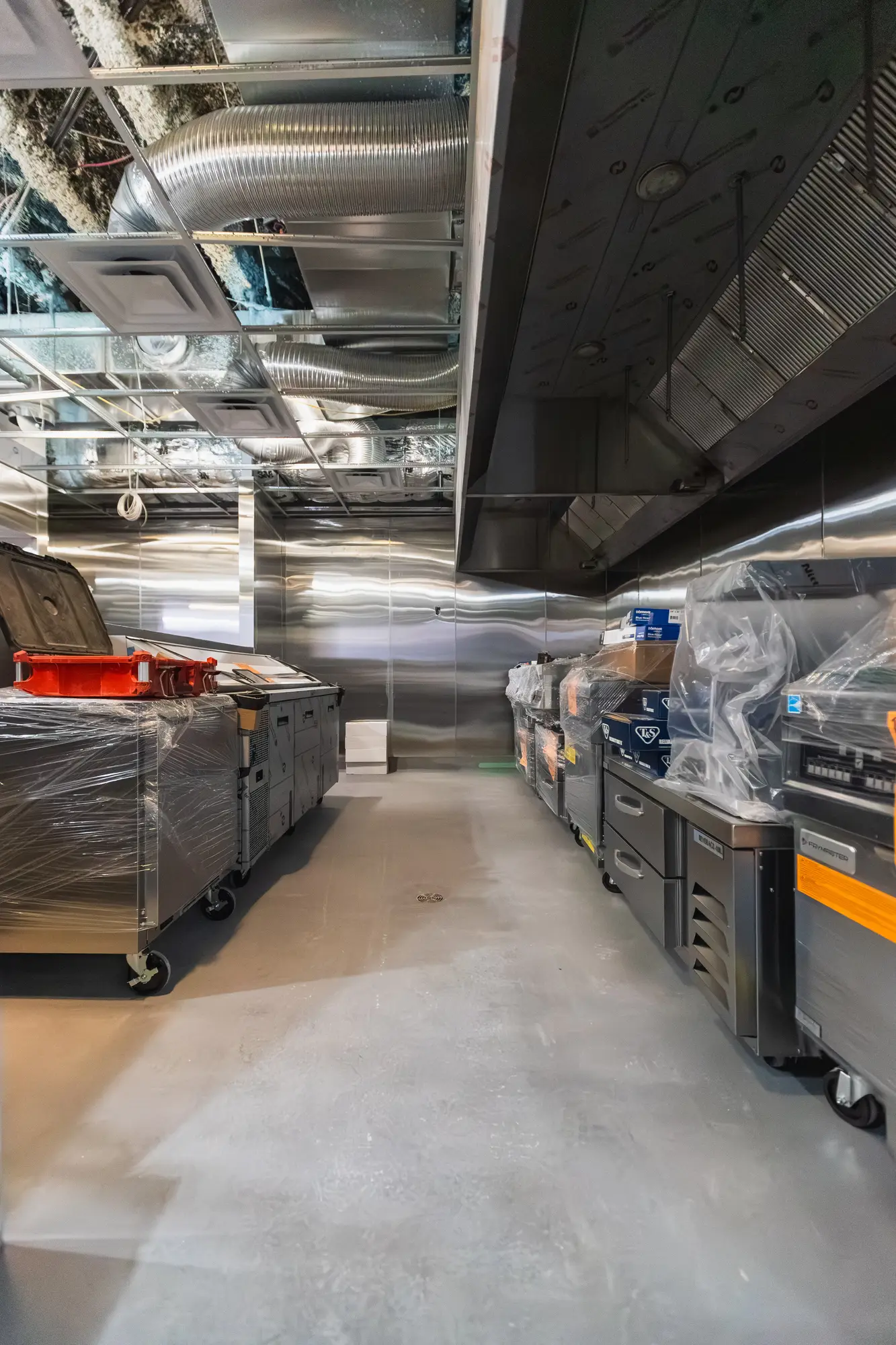Wrapped commercial kitchen equipment staged on site before installation