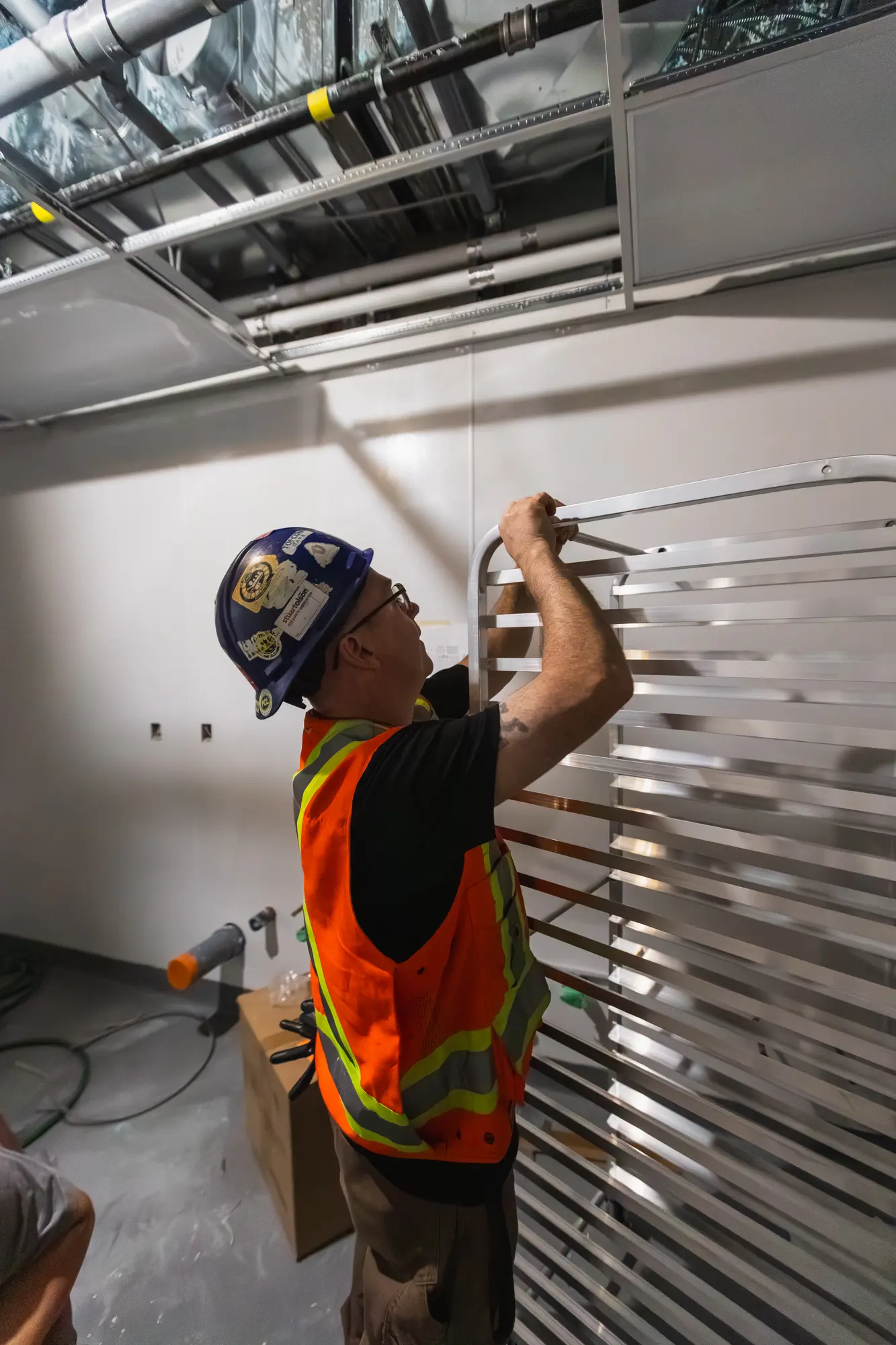 Installer fitting stainless wall cladding at Shake Shack Square One