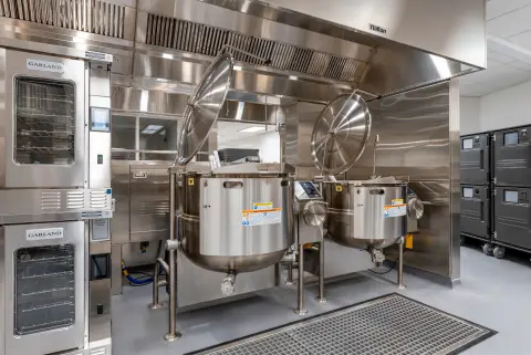 Tilting kettles beside stacked convection ovens